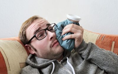 Man laying on couch post op recovering from wisdom teeth removal.